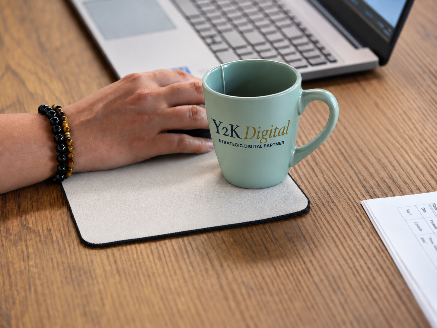 Scrivania ordinata con notebook, tappetino neutro e tazza personalizzata Y2K Digital, Strategic Digital Partner